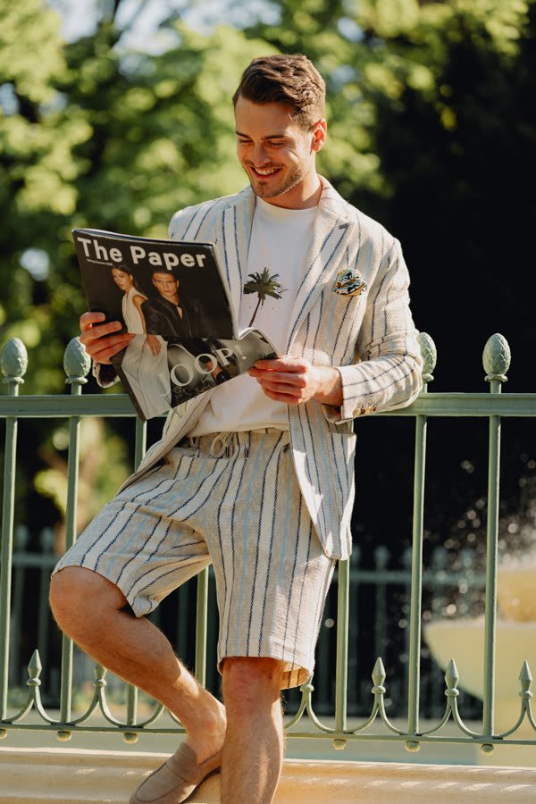 Andreas Schmid, striped summer suit, reading a newspaper