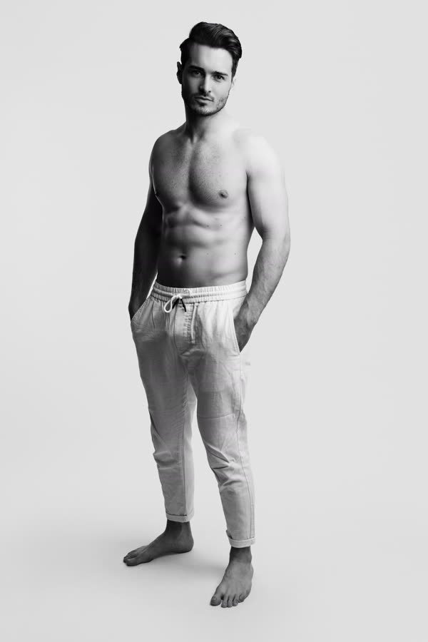 Andreas Schmid, black and white full length studio photo in linen trousers