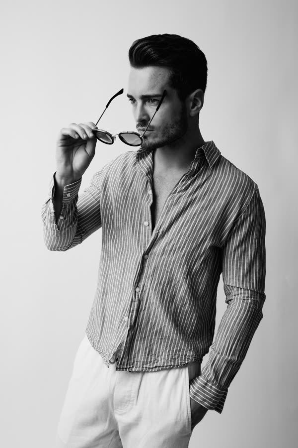 Andreas Schmid, black and white studio photo, taking off sunglasses