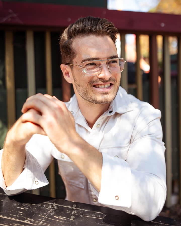 Andreas Schmid, eyewear campaign, seated in clear glasses