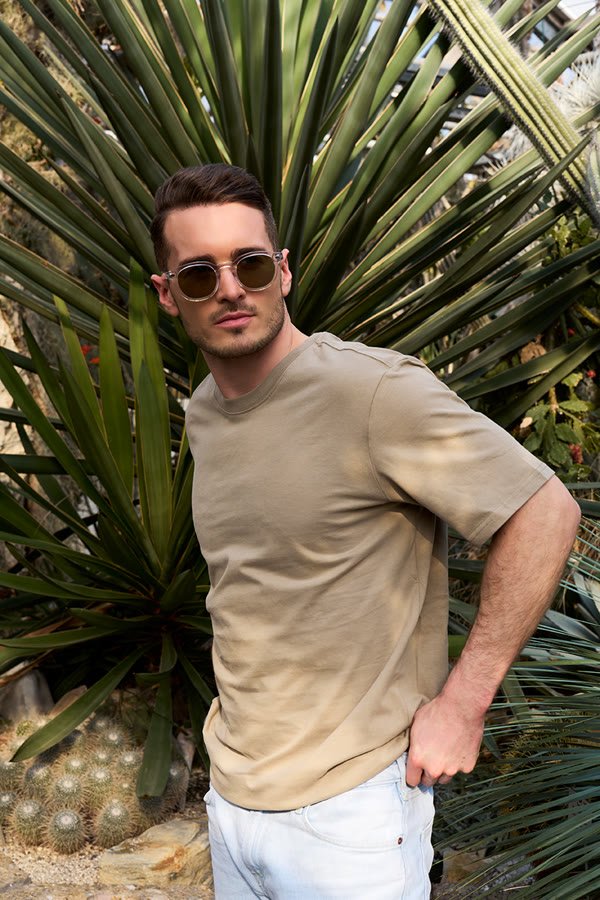 Andreas Schmid, beige T-shirt and sunglasses among agaves
