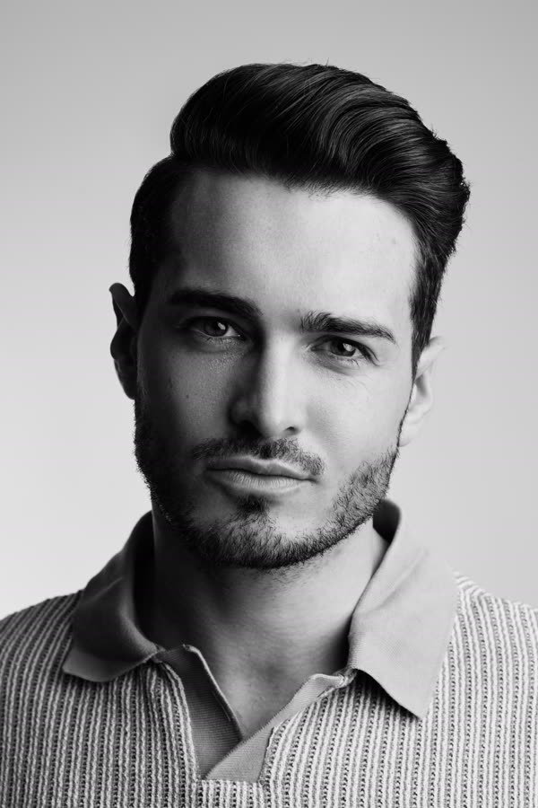 Andreas Schmid, black and white studio portrait in a knitted polo