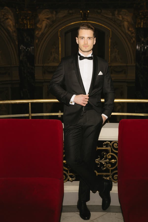 Andreas Schmid, tuxedo between red velvet chairs
